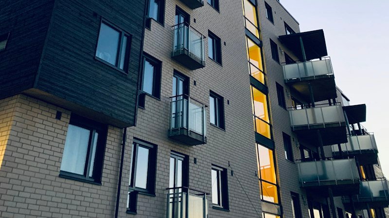 Elm & Ash: brick-faced infill homes stepping along the block, each with a balcony to the street